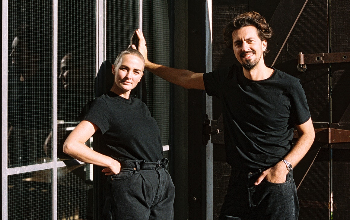 Youswim founders, dressed in black, pose against a wall.
